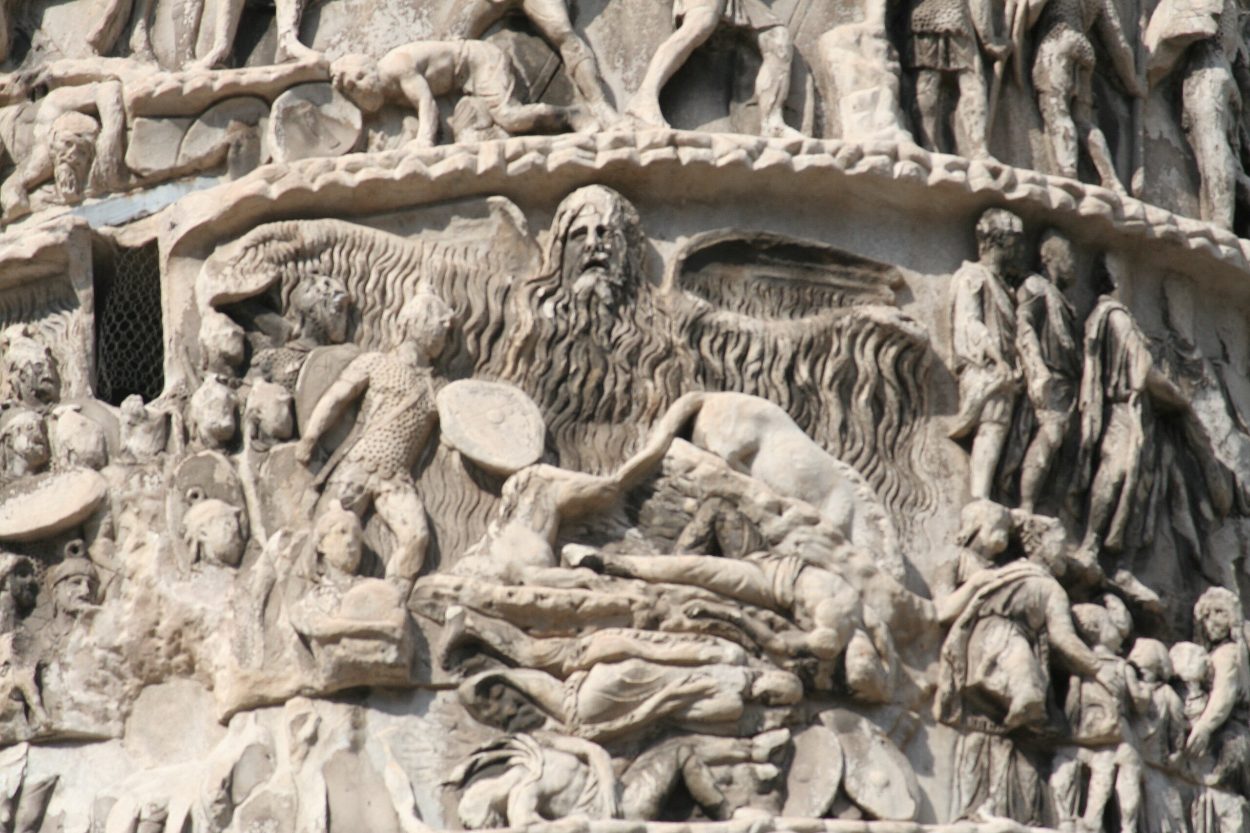 A marble carving depicts a winged, god-like figure is depicted at the center of the composition. He summons clouds and lightning over the soldiers below.